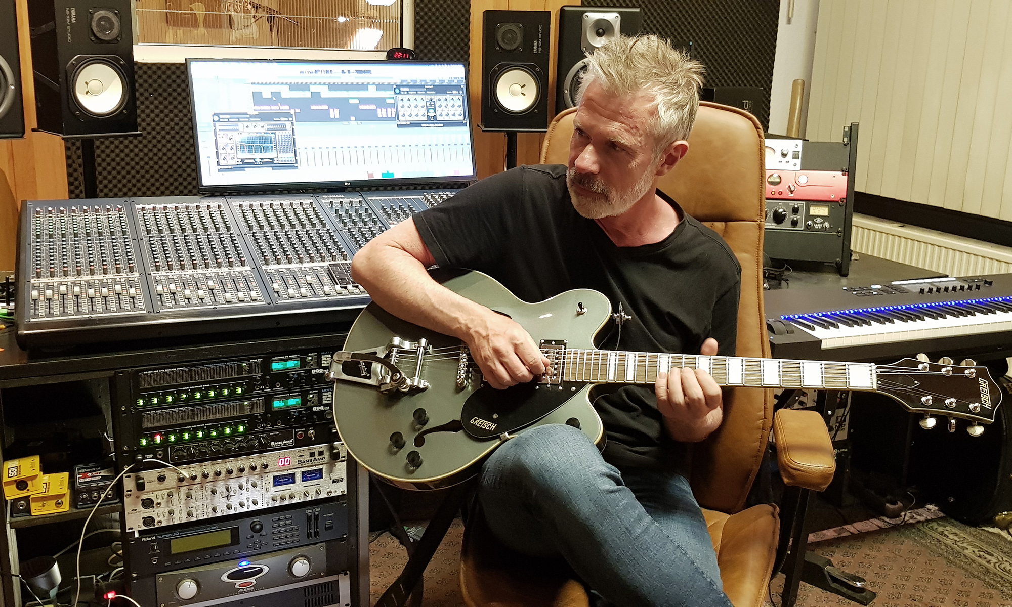 Pete Larsen am Pult mit Gitarre